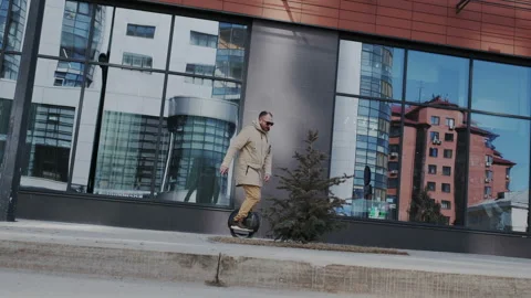 Handsome bearded man is riding hoverboard or electric self balancing monowheel Stock Footage 106494545