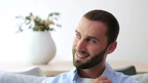 Handsome bearded man smiling and relaxing at home 스톡 동영상 335588171