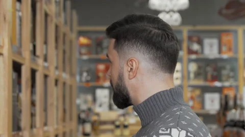 Handsome bearded man smiling to the camera while shopping at the supermarket Stock Footage 147407675