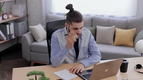 Handsome bearded man studying online using laptop web camera, writing lecture in Stock Footage 181502841