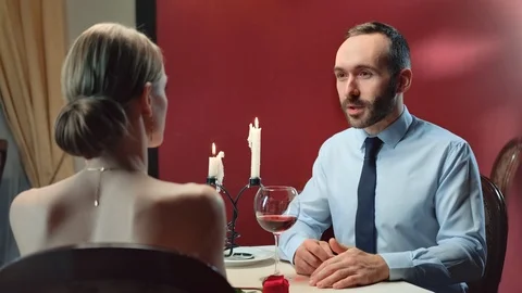 Handsome bearded man in suit talking with elegance female at romantic date. Wide Stock Footage 124525991