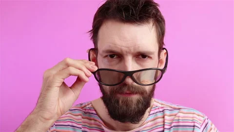 Handsome bearded  man in sunglasses looking at the camera and blinking eye Stock Footage 134231680