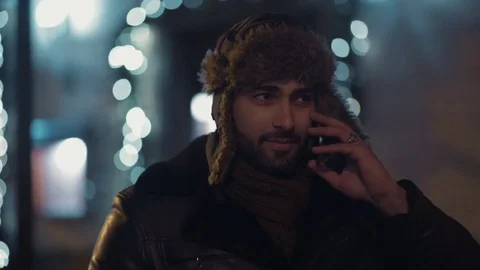 Handsome bearded man talking via his phone while standing in the city center Video stock 84652801