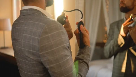 Handsome bearded man is using atomizer nozzle with perfume Stock-Footage 116335335