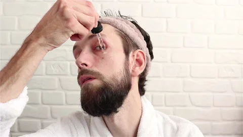 Handsome bearded man using dropper with serum collagen skin care product Stock Footage 153005430