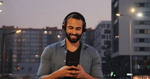 Handsome Bearded Man Walking Outside in the City. Using Music Playlist. Stock Footage 97929971