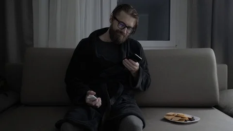 Handsome bearded man watching tv Stock Footage 104304592