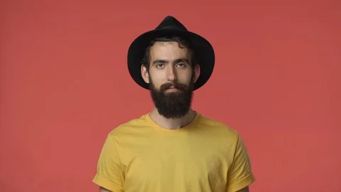 Handsome bearded middle-eastern man in yellow t-shirt, black hat nod acceptingly Stock Footage 115777587