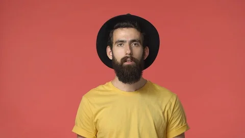 Handsome bearded middle-eastern man in black hat, yellow t-shirt widen eyes Stock-Footage 115781429