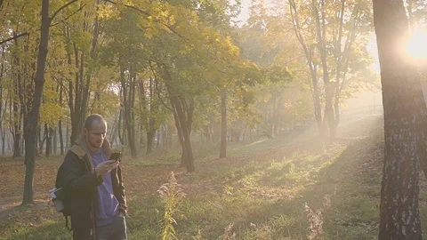Handsome bearded young man talking phone mobile in the autumn park Stock Footage 96278534