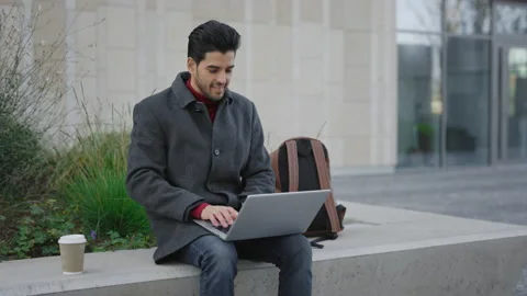 Handsome Beared Multi Ethnic Man Sitting Outside near Office Centre Working on Stock Footage 237604820