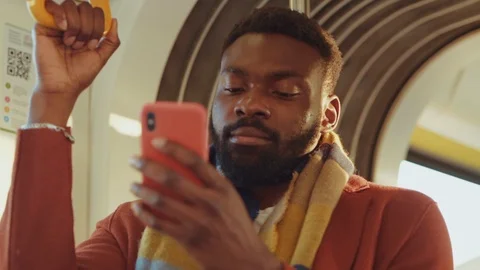 Handsome black bearded guy in coat using smartphone driving inside tram. Happy Video stock 121475457