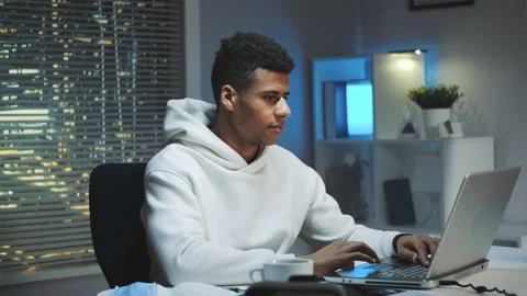 Handsome black man smiling to the camera while working home Stock Footage 131535495