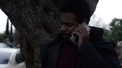 Handsome Black Man Talking on Smartphone in Neighborhood Stock Footage 146163918