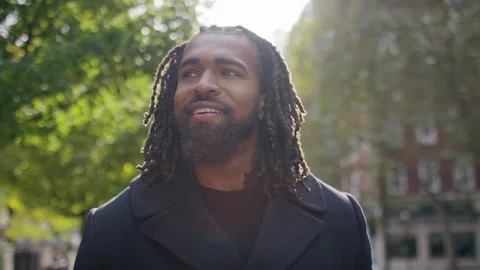 Handsome black man walks through the sunlight in the city, in slow motion Stock-Footage 142798693
