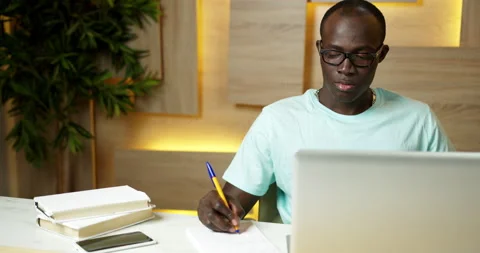 Handsome Black Student Studying Using Laptop, Writing a Lecture in Notebook Stock-Footage 159616867