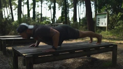 Handsome blond guy doing sport outdoor on wooden table, doing push ups, fitness Video stock 119346116