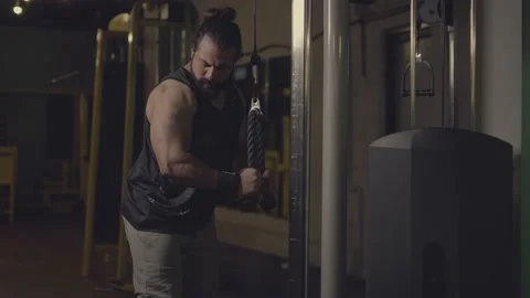Handsome bodybuilder athlete with beard and man-bun doing triceps exercise us Stock Footage 161320832