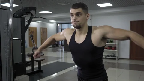 Handsome bodybuilder excercises in gym Stock Footage 102740371