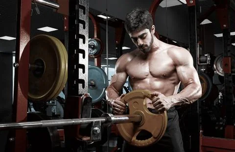Handsome bodybuilder guy prepare to do exercises with barbell Stock Photos