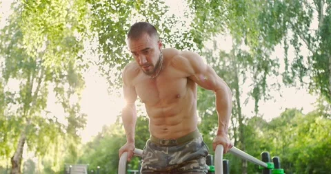 Handsome bodybuilder performing exercise on parallel bars alone.Man doing push Stock Footage 157207911