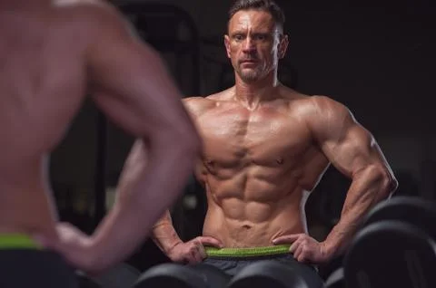 Handsome bodybuilder posing in gym Stock Photos
