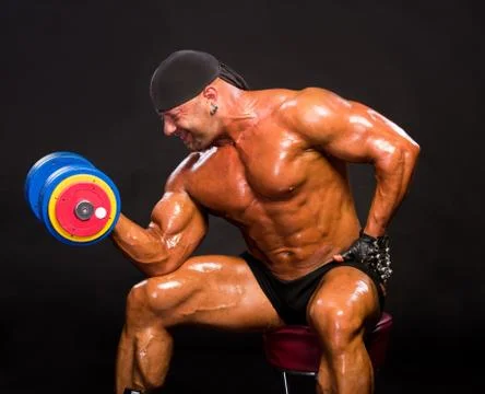 Handsome bodybuilder training with heavy dumbbell Stock Photos
