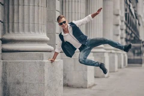 Handsome bouncing with joy guy walk on the street. Summer fashion. Summer hol Stock Photos