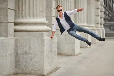Handsome bouncing with joy guy walk on the street. Summer fashion. Summer hol Stock Photos