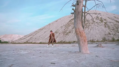 Handsome boy dance at sunset, background white mountain and blue sky Stock Footage 138865240