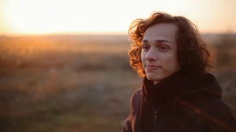 Handsome boy in the field at sunset. Close up 動画素材 98749645