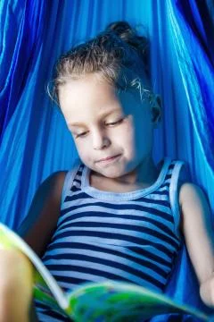 Handsome boy reading a book in a hammock Stock-Fotos
