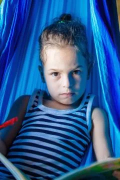Handsome boy reading a book in a hammock Fotos Stock