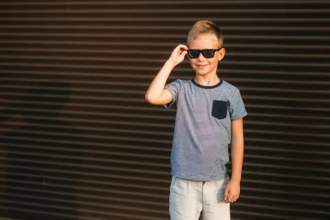 Handsome boy smiling and posing to the photographer. Boy have sunglasses. Young 写真素材