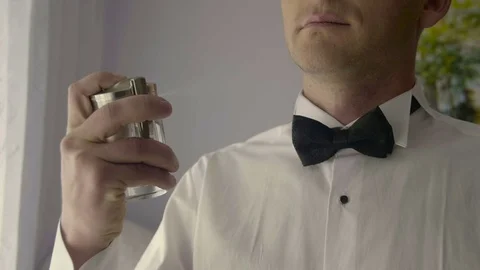 Handsome bridegroom using perfume on wedding day Stock Footage 70255866