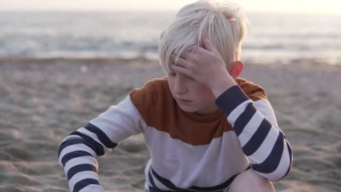 A handsome brooding boy is blonde against the backdrop of the sea Stock Footage 229859508
