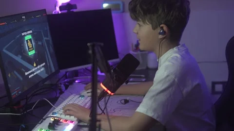 A handsome brunette boy plays the computer game Roblax in a dark room with a Stock Footage 307600794