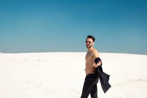 A handsome brunette guy with a bare torso stretches out his hand Stock Photos