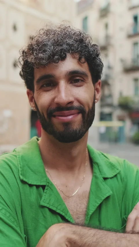 Handsome brunette guy with beard, dressed in green shirt, crosses his arms while Stock Footage 255505152