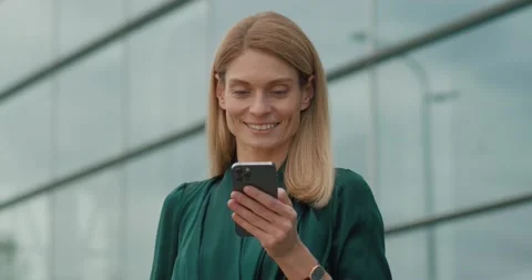 Handsome Business Lady smiling while Browsing on Social Media uses Phone Stock Footage 162754228