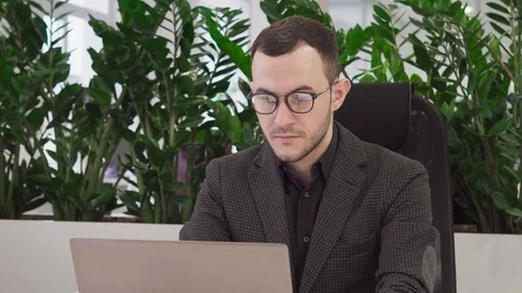 Handsome business man using a laptop looking at the camera and smiling Stock Footage 85489829