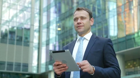 Handsome business man using tablet computer on the street Stock Footage 68385792
