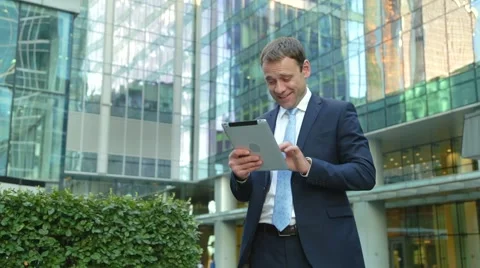 Handsome business man using tablet computer on the street Stock Footage 68385882