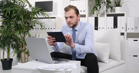 Handsome Business Worker Man Working on Computer Tablet Sitting on Sofa Office Stock Footage 87982687