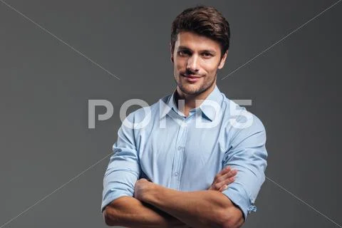 Handsome businessman with arms folded looking at camera Stock Photos