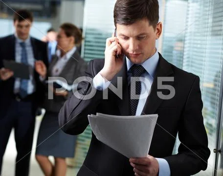 A handsome businessman calling by the phone in working environment Stock Photos