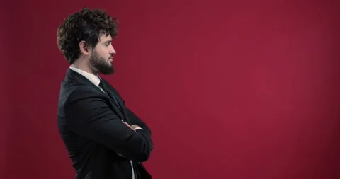 Handsome businessman checking the time with his wristwatch, isolated on red b Stock Footage 136885794