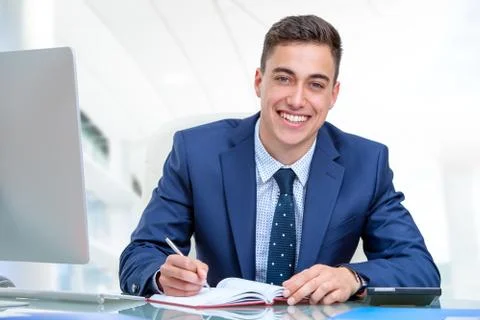 Handsome businessman at desk in office. Stock Photos