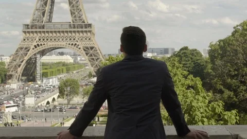 Handsome Businessman posing at the Eiffel Tower after work, with a black jacket, Vídeo Stock 111923844