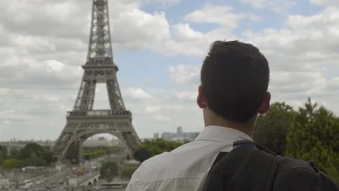 Handsome businessman posing at the Eiffel Tower after work, with a white shirt, 動画素材 111926577